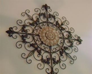 Metal and ceramic wall art is 42 inches in diameter.