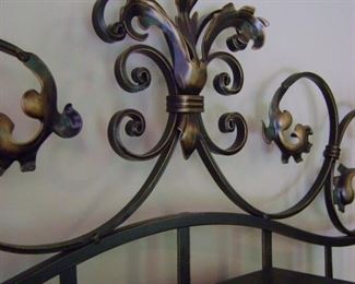 Closeup of wine rack detailing beautiful  metal scroll motif.