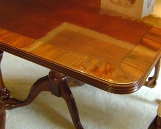 Almost brand new inlaid wooded finish with intricate ball and claw feet dining table.  Measures 68 by 44.  Includes full padded table top and 2 additional leaves.
