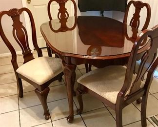 Dining room table with glass cover and upholstery chairs.