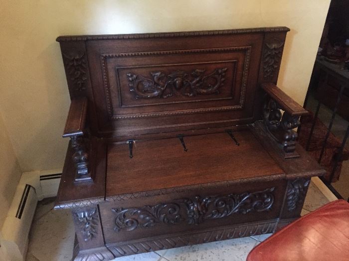 antique front hall seat , highly carved with lions and storage
