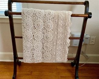 hand crocheted coverlet hanging over an antique quilt rack.