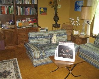 3-piece wood shelf unit containing books, retro sofas