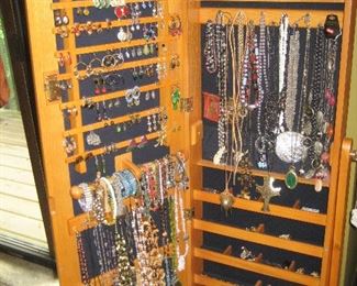 Wooden jewelry cabinet with assorted jewelry