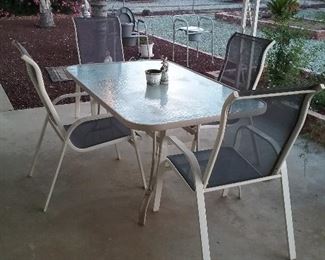 Glass top patio table with 4 blue & white mesh chairs