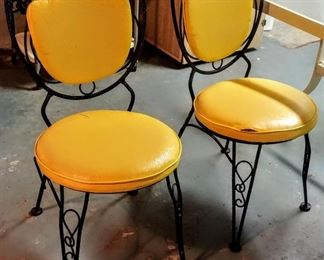 retro rod-iron bistro chairs with yellow cushions