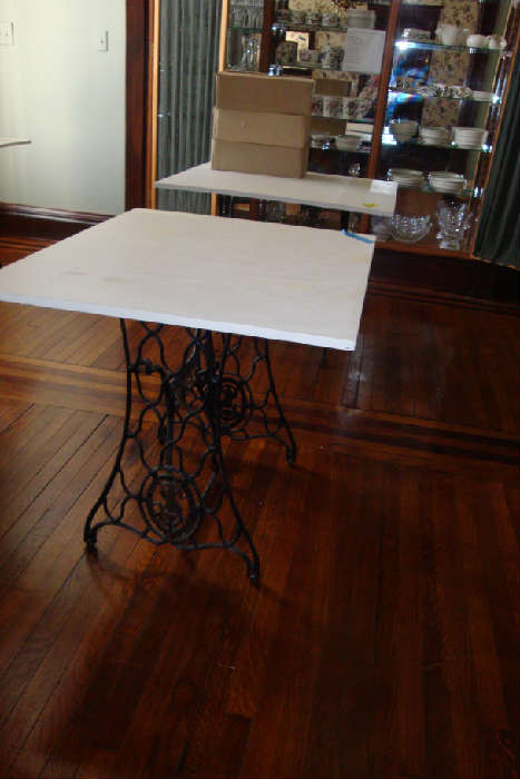 3 tables with tops set on antique treadle sewing machine bases.
