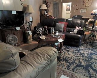 Navy blue leather sofa.  Glass-Iron end table.  Small credenzas.  Two (2) flat screen tvs. Dale Tiffany Lamp.  Large Area Rugs