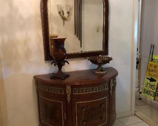 Demilune chest. Neoclassical style, marquetry inlaid. Shaped top over three gilt drawers. Guild framed drawers and cabinets, gilt accented feet. Marquetry inlaid, gilt accented mirror.