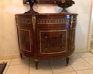 Demilune chest. Neoclassical style, marquetry inlaid. Shaped top over three gilt drawers. Guild framed drawers and cabinets, gilt accented feet. Marquetry inlaid, gilt accented mirror.
