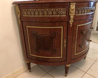 Demilune chest. Neoclassical style, marquetry inlaid. Shaped top over three gilt drawers. Guild framed drawers and cabinets, gilt accented feet. Marquetry inlaid, gilt accented mirror.