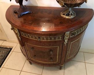 Demilune chest. Neoclassical style, marquetry inlaid. Shaped top over three gilt drawers. Guild framed drawers and cabinets, gilt accented feet. Marquetry inlaid, gilt accented mirror.