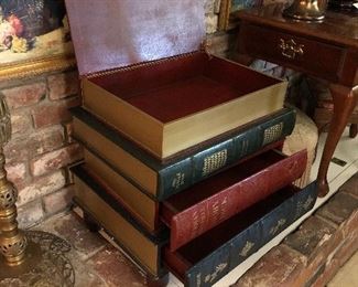 Stacked, gilded leather trompe l’oeil book table. This large stack of books offer storage in a lift top and two bottom drawers.