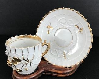 Ivory and gold tea cup and saucer in display stand