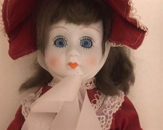 Detail of bisque doll with glass eyes, painted lashes, cloth body and leather boots