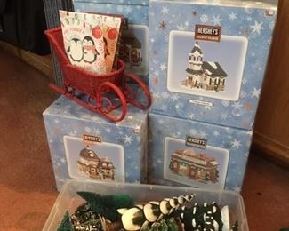 Boxed Holiday Village Buildings in Porcelain and lighted by Hershey; also boxed accessories such as carolers, snowmen, and different styles of trees