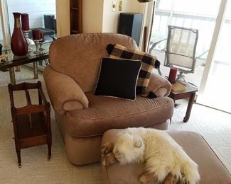 Overstuffed chair & ottoman with cat-form stuffed animal looking right at home!