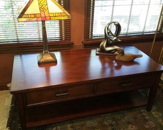 Low table (top is cantilevered to come up and over the lap of someone seated in front of it),  leaded glass lamp, etc, in the Den