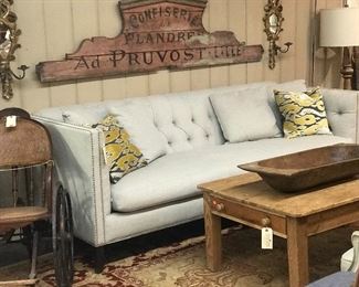 Modern tufted sofa in gray. Trimmed with silver nail heads.