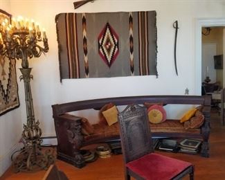 Most unusual circular griffin carved sofa. Indian blankets. Shown one of a pair of large impressive torcheres.