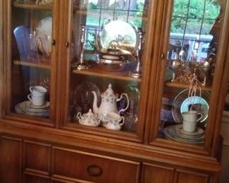 Cherry china cabinet filled with silver plate and ceramic dishes