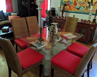 Glass-Top Dining Table & Chairs. This contemporary glass -topped table can seat six and comes with 6 wicker chairs with red cushions