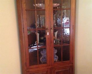 Corner cabinet with upper display area and lower storage space.