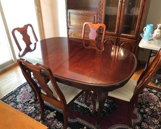 Wood Dining Room Table Features Two Leafs and Four Chairs