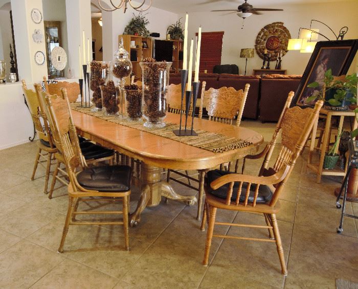 Large oak dining table with 8 chairs. It also has leaves that can come out to make the table smaller.