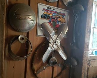 Vintage hubcaps and steering wheel and old licence plates