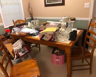 Ceramic tile top kitchen table with 4 chairs and what looks like a lot of stuff Cher hasn't set up yet. Snap to it, Cher!