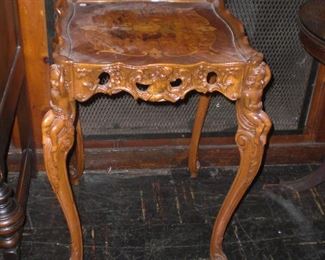 heavily carved side table with cherubs and marquetry top