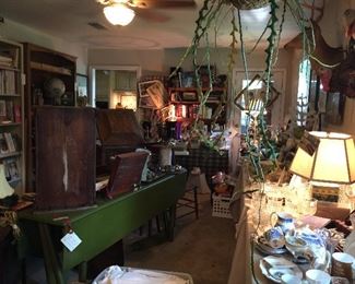 In the game room you will find this wonderful long green drop leaf table, old clock, chairs, Victorian love seat,and lots more 