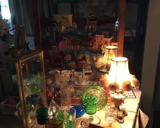 The tall showcase has vintage doll house furniture and doll house size families, vintage cigarette holders from the 30's, collection of candy containers 