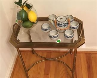Solid brass table with glass top that can serve as a serving tray.