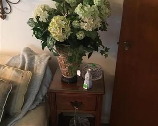 Beautiful floral arrangement in beautiful vase.  Small table with drawer and bottom shelf.