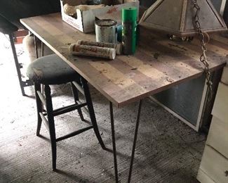 fab Metal butterfly table with hairpin legs. The leaves are underneath and when the table is pulled apart, the leaves pop up. Old wooden stool with leather top and brass tacks. Hanging light. All items are being moved to the back porch