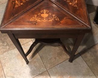 This is an antique handkerchief game table with marquetry. On consignment.