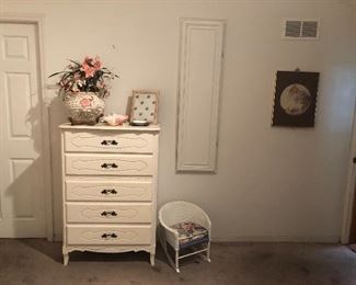Child’s wicker rocker and white dresser.
