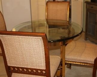 Glass and brass dining table with four chairs.