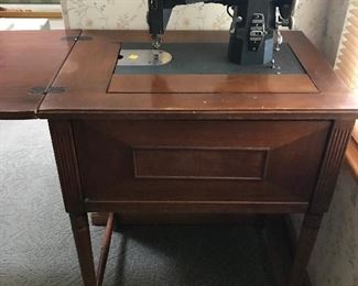 Antique sewing machine in cabinet