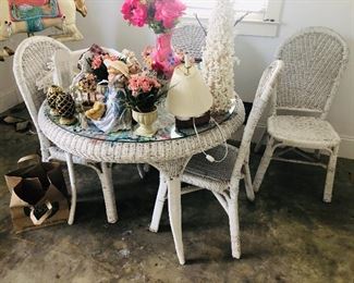 Round white wicker table with 4 chairs.