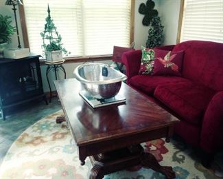 red loveseat, clawfoot coffee table