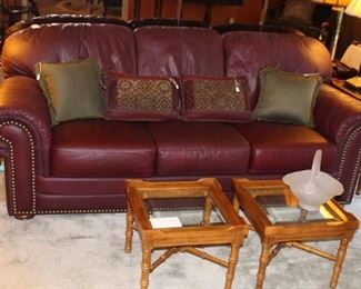 Leather sofa shown with pair of cocktail tables.  