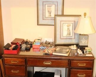 Desk, printer and lots of office supplies and glass frames.  