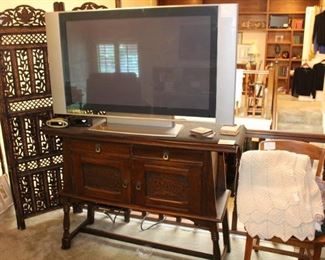 TV is shown on top of antique oak server.  