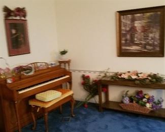 piano, behind the sofa table , flowers and more picture has been sold