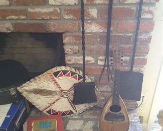 Fireplace Tool Set. Small Banjo Instrument, needs repairs. Guitar Songbooks. Flutes. Decorative Folk Art Tribal Shield. Set of Brass Flamenco Instruments.