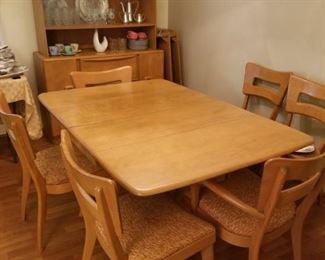 Heywood wakefield dining set with 4 extra leaves, also a drop leaf table if you want. Original seat covers in orange and turquoise, matching hutch with glass doors. All in excellent condition