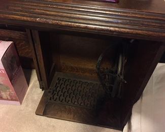 vintage treadle machine in oak cabinet